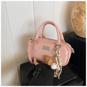 Detail of pink glossy leather bowling bag with a baseball glove keychain and silver logo