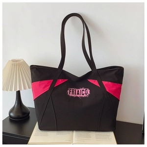 Detail view of canvas tote bag with pink side panels and pink artistic typography