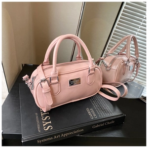 Detail of pink faux leather bowling bag with silver logo plaque on art book