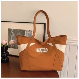 Detail of color-block canvas tote bag featuring FRIAICG lettering and large storage capacity