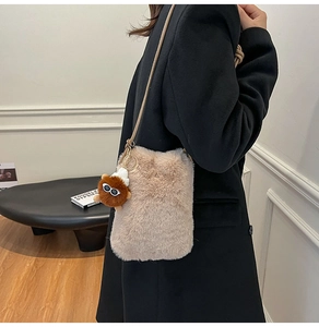 Detail of plush beige crossbody bag with faux fur texture and cute bear charm
