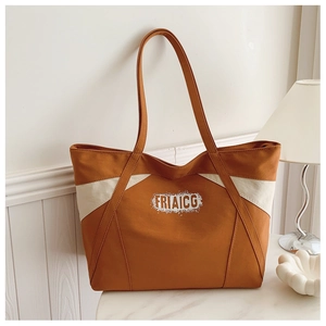 Detail of contrast color canvas tote bag with thick shoulder straps and FRIAICG logo print
