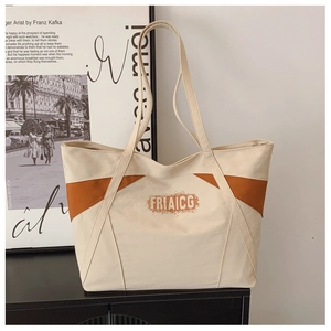 Detail of color-block canvas tote bag with brown trim and FRIAICG logo text