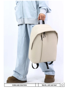 Detailed side view of beige minimalist backpack with vertical zipper and fabric handle
