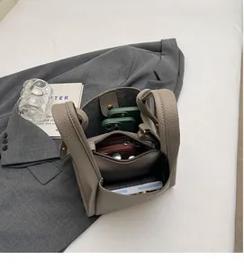 Interior view showing the large capacity and compartments of the lychee leather bucket bag
