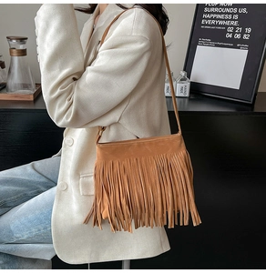 Detail der karamellfarbenen Wildleder-Umhängetasche mit Fransen und Boho-Stil