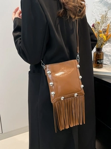 Fashionable brown fringe bucket bag with silver studs and tassel details in bohemian style