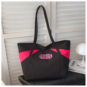Close-up of pink diagonal patchwork and FRIAICG logo on black canvas tote bag