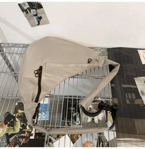 Close-up of nylon dumpling bag with metal zippers and adjustable strap on metal mesh