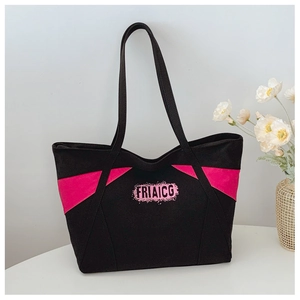 Close-up of black canvas tote bag with pink triangle splice and FRIAICG print logo