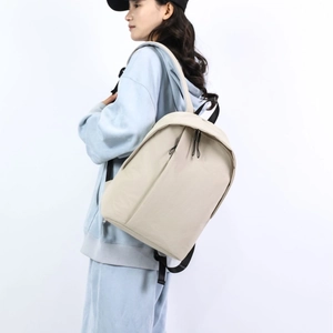 Minimalist beige backpack with stylish black contrast straps for travel and school