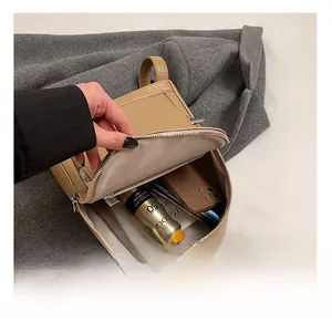 Interior view of khaki faux leather backpack showing large storage capacity and fabric lining
