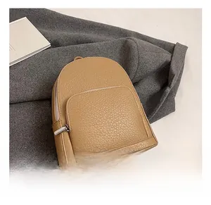 Top view of khaki faux leather backpack with pebble grain texture and zipper detail