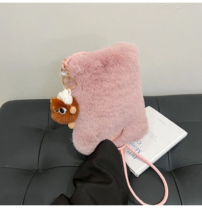 Detailed macro view of pink plush crossbody bag with a cute brown bear charm
