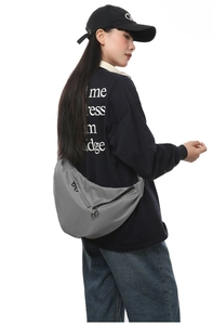 Detailed view of the large grey waterproof nylon crescent crossbody bag on model