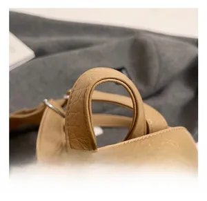 Detailed close-up of khaki pebbled leather handle with durable reinforced stitching