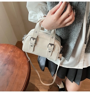 Détail d'un sac Boston vintage beige avec boucles parallèles et garnitures argentées