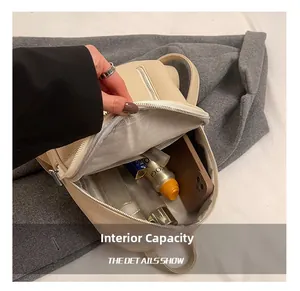 Detail view of beige backpack interior showing organized space for phone and cosmetics