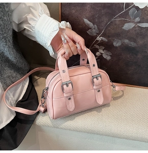 Détail d'un mini sac Boston rose en cuir PU brillant avec boucle argentée et deux poignées