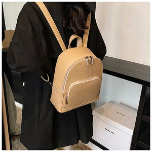 Detailed view of beige pebble leather backpack with adjustable straps and silver zipper