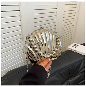 Detailed view of shell-shaped silver evening bag with beaded edges and metallic chain