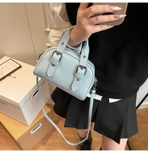 Détail du sac bandoulière bleu clair avec finition brillante et boucles argentées