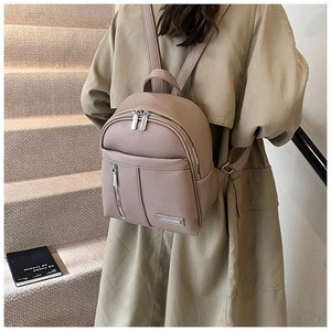 Close-up of pebble grain leather mini backpack in dusty pink with metal logo detail