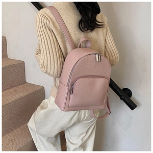 Detail of pink faux leather mini backpack with pebble texture and silver zippers