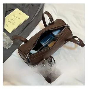 Internal capacity of the brown cylindrical Boston bag showing cosmetics and daily essentials