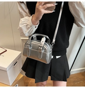 Détail du mini sac Boston argenté avec doubles boucles et bandoulière amovible