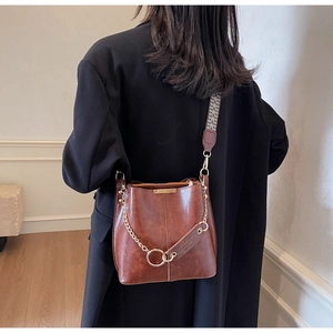 Détails du sac seau marron avec bandoulière jacquard géométrique et chaîne en métal