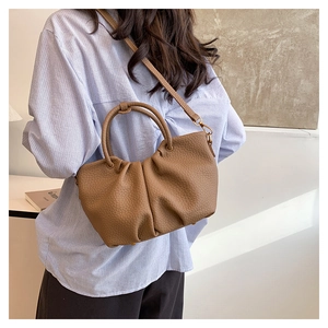 Sac nuage en cuir marron avec bandoulière amovible dans un décor de style de vie décontracté