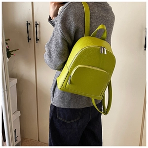 Detailed view of lime green lychee leather mini backpack with silver metal zippers