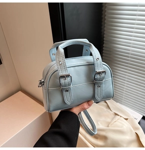 Détail du mini sac Boston bleu clair avec boucles argentées et bandoulière amovible
