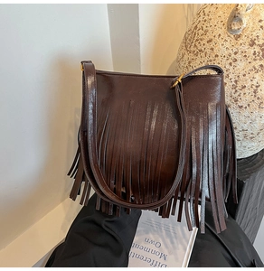 Nahaufnahme einer dunkelbraunen Fransen-Beuteltasche aus glänzendem PU-Leder im Retro-Stil