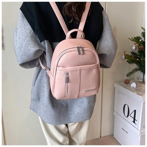 Close-up of pink lychee textured leather backpack with silver zippers and side pockets