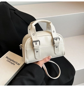 Détail d'un mini sac à main en cuir PU crème avec poignée supérieure et bandoulière réglable