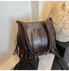 Detailaufnahme der dunkelbraunen Fransen-Beuteltasche mit eleganten goldenen Schnallen