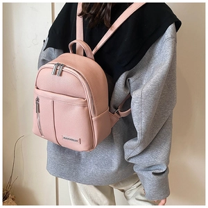 Close-up of pink pebbled leather mini backpack with metal logo and silver zipper details