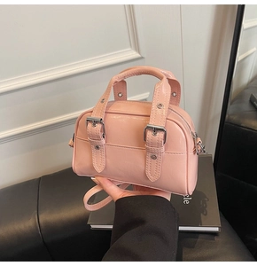 Détail du mini sac bandoulière en cuir verni rose avec boucles argentées et zip