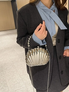 Silver shell-shaped evening bag with metallic texture, beaded handle and chain strap