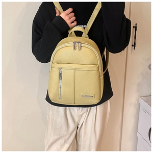Detailed texture of lychee grain leather mini backpack in pale yellow on model back