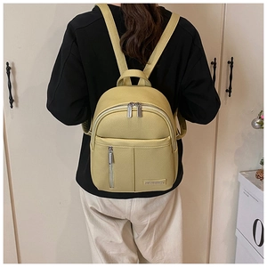 Close-up of light yellow lychee grain leather mini backpack with metal logo plate