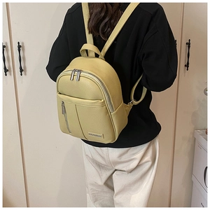 Detail view of lime yellow pebbled leather backpack showing vertical stitching and zippers