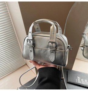 Détail du mini sac à main argenté métallisé avec sangles à boucle sous une lumière naturelle