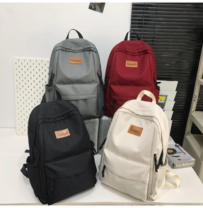 Group shot of colorful waterproof nylon backpacks in black, red, grey, and cream colors