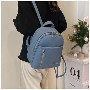 Blue lychee textured leather backpack detail with metal zipper and luxury holiday decor