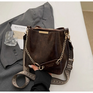Détail du sac seau marron café vintage avec chaîne dorée et bandoulière boho