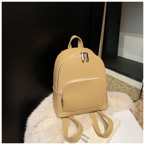 Detail of beige pebble leather backpack with silver zippers on a soft white fur stand