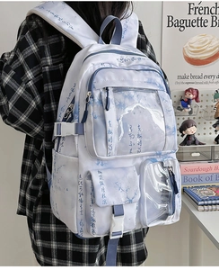 Detail of white backpack with blue Chinese landscape print and multiple storage pockets